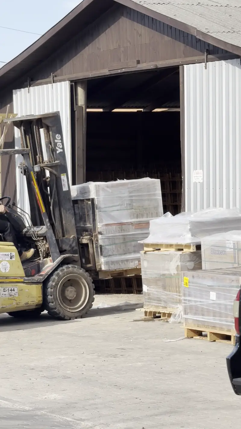 Empilhadeira carregando pallets de material no depósito da Beira Mar